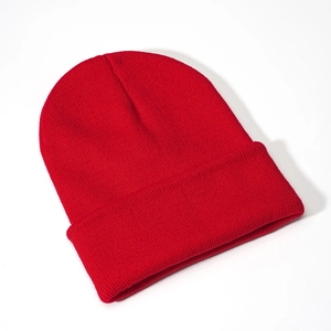 Close-up of bright red knitted beanie showing fine texture and ribbed cuff design