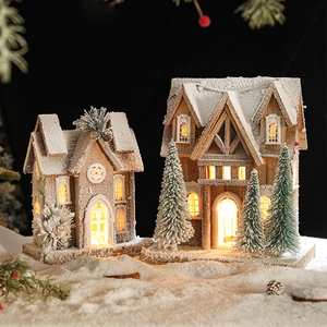 Lighted wooden Christmas cabin ornaments with warm LED glow and snowy landscape decor