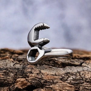 Retro stainless steel wrench-shaped ring standing on bark, creative biker jewelry design