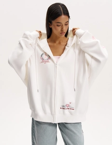 Dettaglio felpa bianca con cappuccio Y2K con slogan 'CONFIDENT' e stampe artistiche