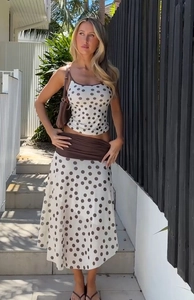 Close-up of summer polka dot crop top and midi skirt set with contrast trim details