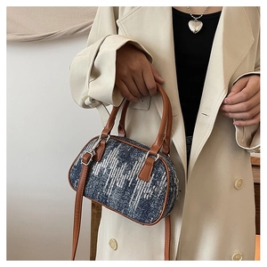 Detailed view of blue denim handbag with sparkling silver sequins and brown leather straps