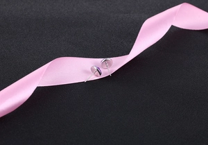 Macro shot of silver stud earrings with purple crystal cluster on pink ribbon
