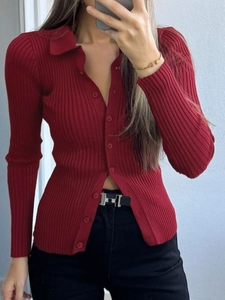 Dettaglio ravvicinato di un cardigan in maglia bordeaux con colletto polo e bottoni
