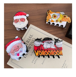Close-up of four cute acrylic Christmas shark hair claws with festive cartoon patterns
