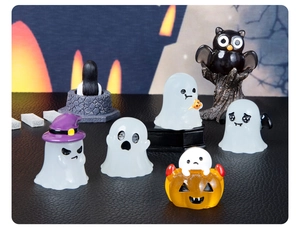 Close-up of Halloween miniature resin set with ghosts, pumpkins and owls on dark background