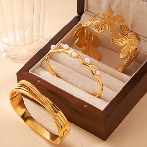 18K gold plated textured bangle set featuring floral openwork and pearl accents