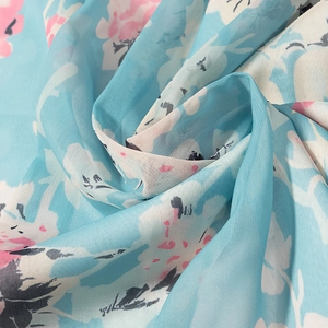 Macro di tessuto in chiffon floreale azzurro che mostra trama e morbido drappeggio