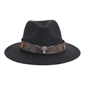 Detail of black wide brim cowboy hat with brown leather band and silver bull head emblem