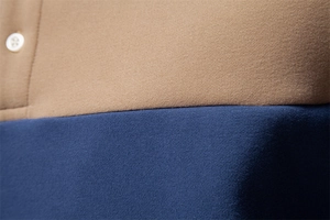 Detailed close-up of khaki and navy stitching with buttons on a polo sweatshirt