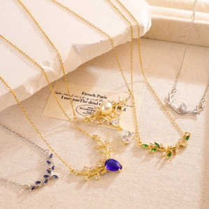 Elegant antler necklaces with pearls and colorful zircons on a beige linen background