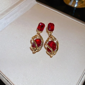 Macro detail of Chinese New Year red faceted gemstone earrings in a golden jewelry box