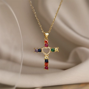 Detailed macro view of gold cross pendant with colorful gems and hollow heart center