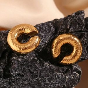Macro shot of 18K gold plated stainless steel C-shape earrings with hammered texture