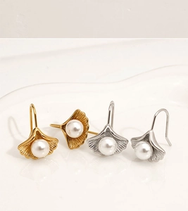 Detail view of gold and silver ginkgo leaf earrings with pearls and hooks