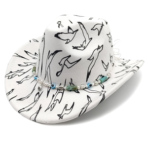Detail of white fedora with bird print, evil eye beads, and a silver shell pendant