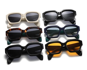 Flat lay of vintage thick-frame polygon sunglasses in various colors and tinted lenses