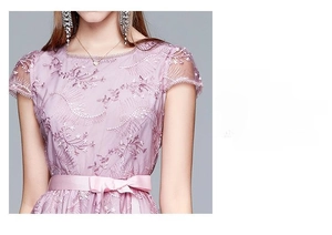 Detail des rosa Spitzenkleids mit floraler Stickerei und Taillenschleife aus Seide