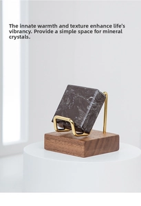 Detail of walnut wood base and brass metal arm holding a black mineral specimen