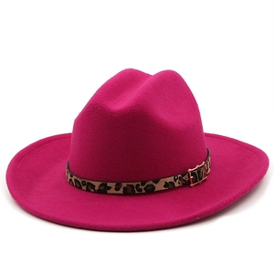 Close-up of hot pink wool fedora hat featuring a leopard print band and gold metal buckle