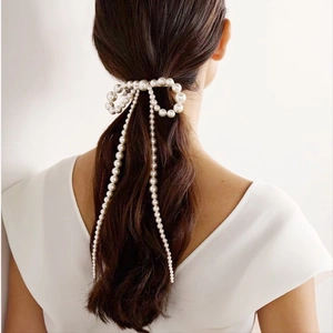 Barrette élégante en perles avec nœud et longs pompons vue de dos sur un mannequin