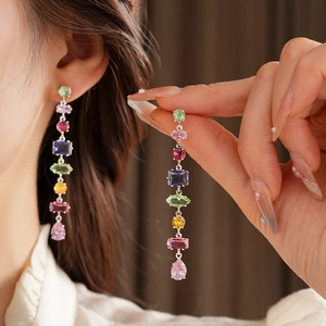 Detail of colorful gemstone drop earrings featuring multi-color crystals in silver setting