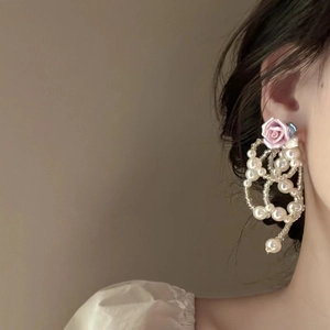 Elegant long pearl tassel earrings featuring a purple resin rose on model's side profile