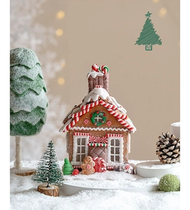 Detailed Christmas gingerbread house ornament with candy decor on artificial snow
