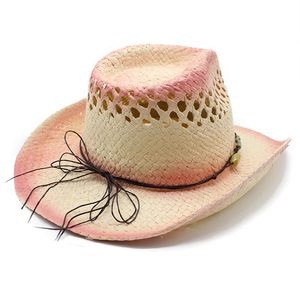 Detail of hollow straw cowboy hat with pink gradient brim and green bead decoration