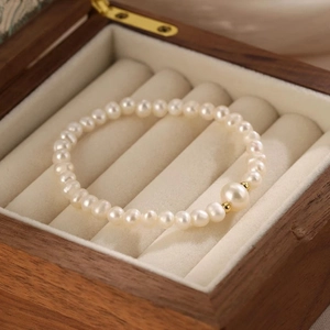 Close-up of fresh water pearl bracelet with gold beads in a wooden jewelry box