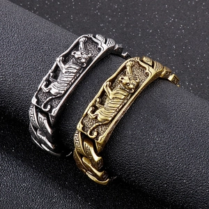 Macro shot of vintage tiger relief carvings on silver and bronze stainless steel bracelets