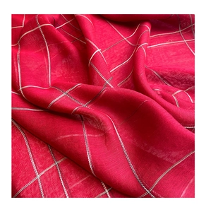 Macro shot of red silk wool scarf featuring a delicate white grid pattern and soft texture