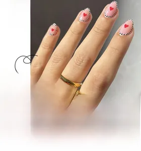 Faux ongles amande courts avec motifs de cœur rouge et bordures à pois noir et blanc