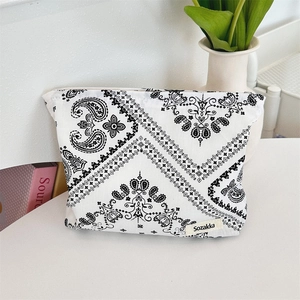 Detail of floral paisley makeup bag with Sozakka label on a white organized desk
