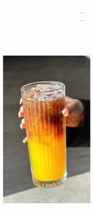 Detailed view of thick textured vertical stripe glass coffee cup with layered iced drink