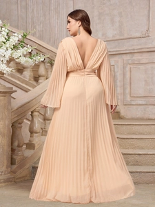 Detail of peach pleated maxi dress with deep V-neck and open back design