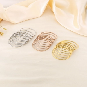 Detailed view of stacked 3mm minimalist bangles in gold, rose gold, and silver finishes