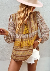 Detail of bohemian chiffon blouse with yellow paisley print and tasseled V-neck cord