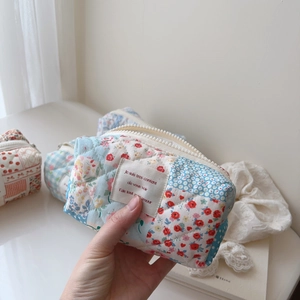 Close-up of quilted cotton makeup bag with blue plaid and red floral patchwork
