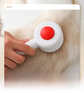 Detail of white silicone pet grooming brush massage comb being used on golden animal hair
