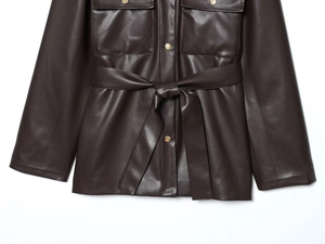 Détails d'une veste longue en cuir marron foncé avec boucles dorées et ceinture à nouer