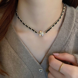 Gros plan du collier en cuir noir avec pendentif sphérique serti de strass brillants