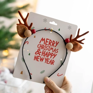 Close-up of reindeer antler headband with brown ears, red berries and gold glitter balls