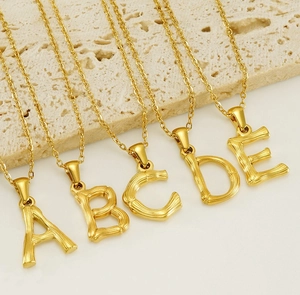 Detailed macro view of golden alphabet necklaces with unique bamboo texture on stone