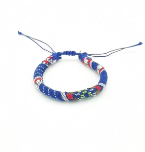 Close-up of handmade woven surfing bracelet with blue bohemian ethnic patterns and tassels