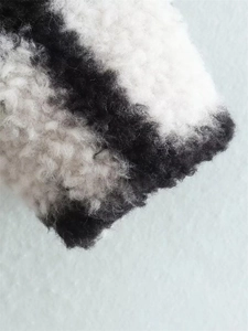 Macro view of black and white checkered sherpa texture on a long winter coat