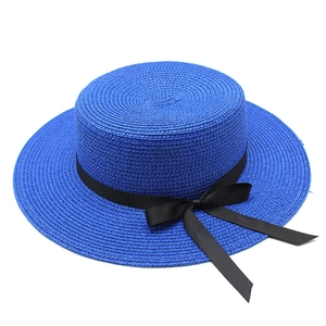 Détail du canotier bleu en paille avec ruban gros-grain noir et élégant nœud décoratif