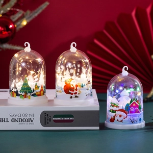 Close-up of LED Christmas scene ornaments in glowing acrylic domes for festive tabletop decor