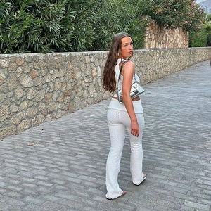 Detailed texture of white two-piece knit set featuring sleeveless top and flared trousers