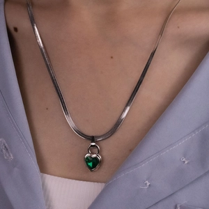 Detail of silver herringbone chain with a deep green heart-shaped gemstone pendant